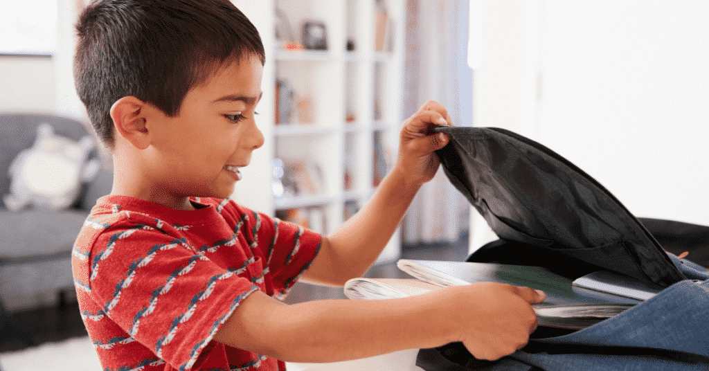 A Boy packing a school bag;My First Day of School Essay -The Ultimate Guide